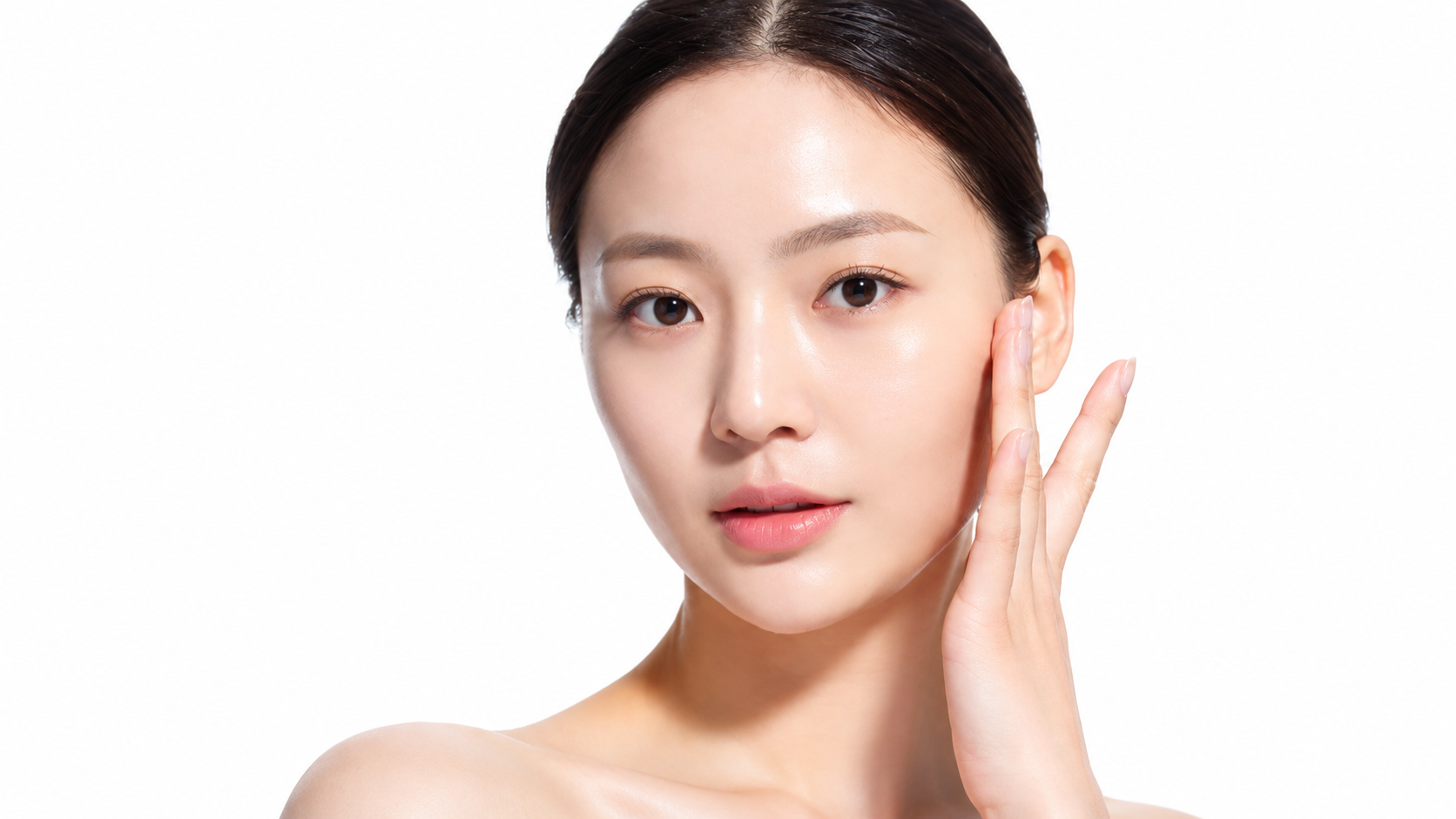 woman touching youthful, radiant face showcasing facial fat grafting and anti-aging surgery results.