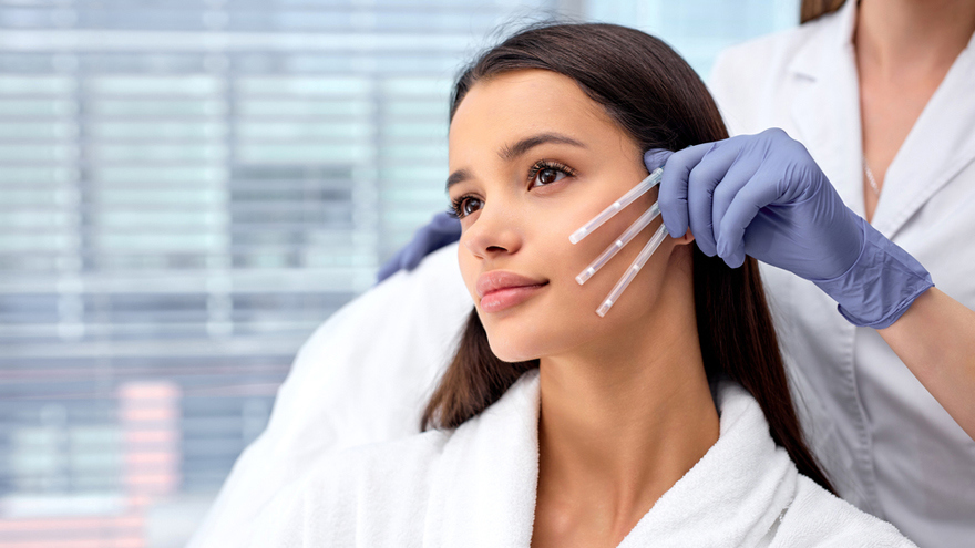 A clinician wearing gloves demonstrates thread lift placement on a female patient’s cheek, representing personalized planning and precise technique for non-surgical facial lifting at Second Spring Women’s Clinic.