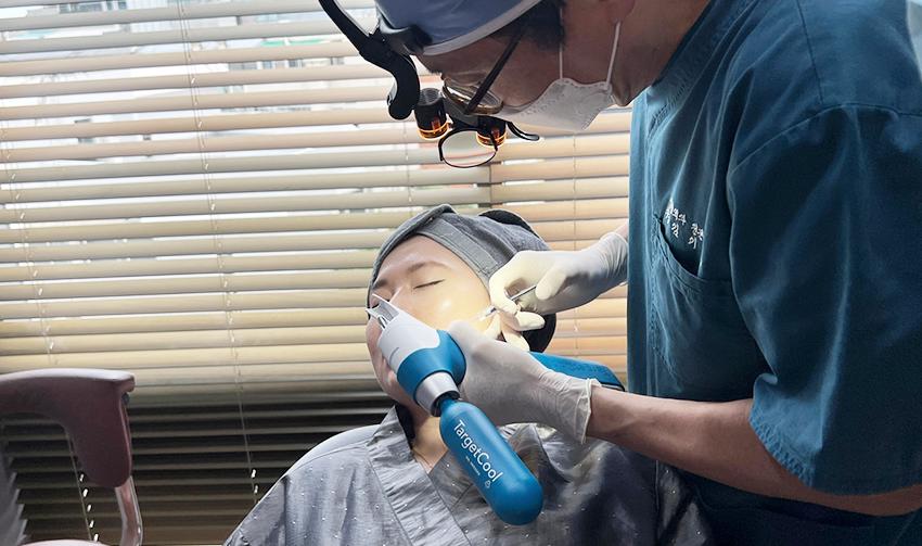 Doctor administering Botox injection using TargetCool precision skin cooling device on patient's face.