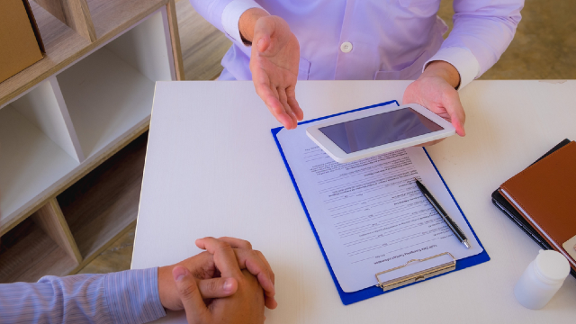 Eyelid surgery consultation: doctor going over a schedule with a patient