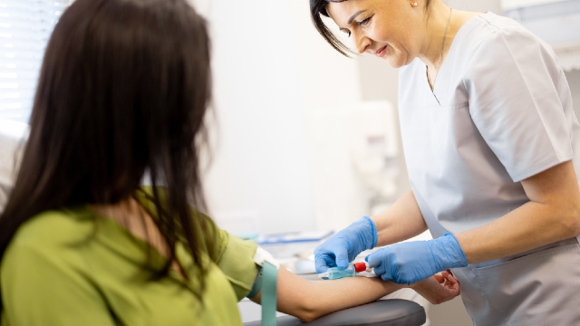 Nurse performing a blood draw from a patient's arm for pre-operative blood testing