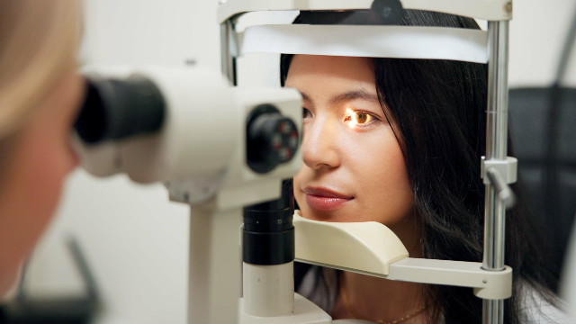 Doctor examining a patient’s eyes during an assessment for revision eye surgery.