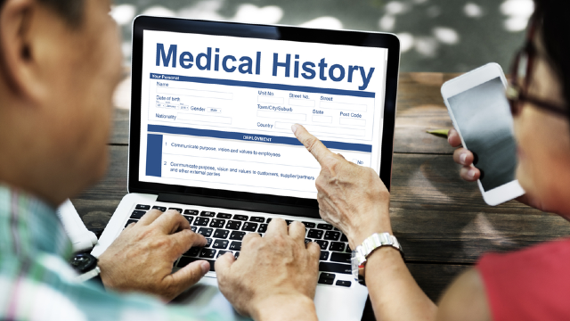 Patient preparing and reviewing a digital medical history document on a laptop before a Korean plastic surgery consultation