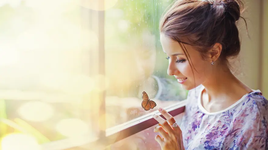 Woman reflecting by a window symbolizing emotional support and recovery during miscarriage management care